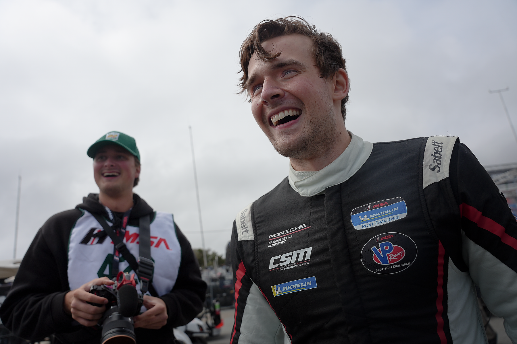 A smiling driver in a black Czabok-Simpson Motorsport race suit between sessions.